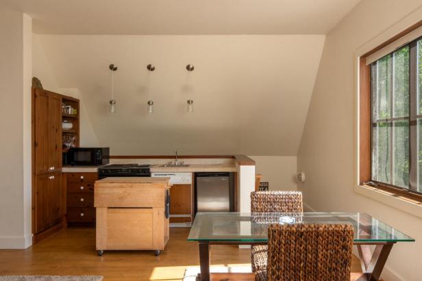 Eine Küche mit Holzboden, einem Esstisch mit Glasplatte und zwei Stühlen.