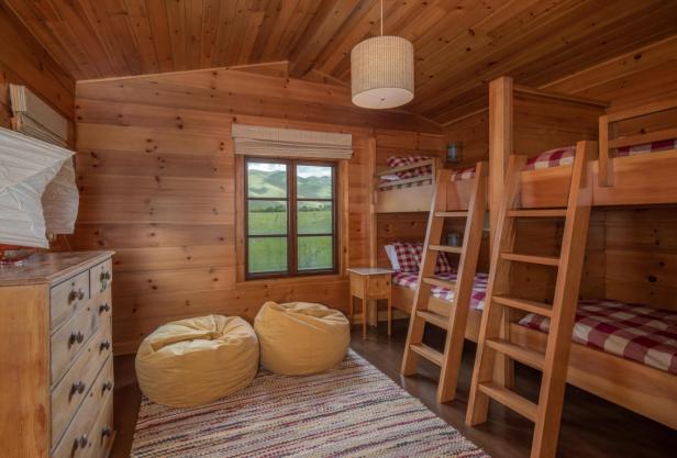 Ein gemütliches Holzzimmer mit Etagenbetten und Blick auf eine grüne Landschaft.