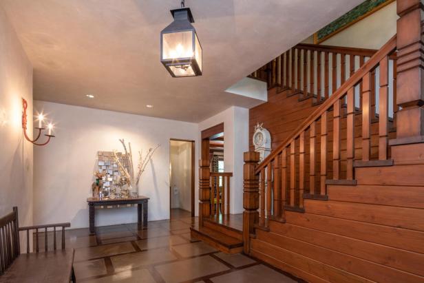 Ein Innenraum mit einer Holztreppe und einem dekorativen Tisch.