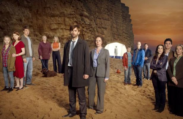 Die Besetzung der Fernsehserie „Broadchurch“ steht am Strand vor einer Klippe.