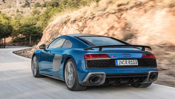 Ein blauer Audi R8 fährt auf einer kurvenreichen Straße.