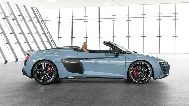 Ein blauer Audi R8 Spyder steht in einem modernen Ausstellungsraum.