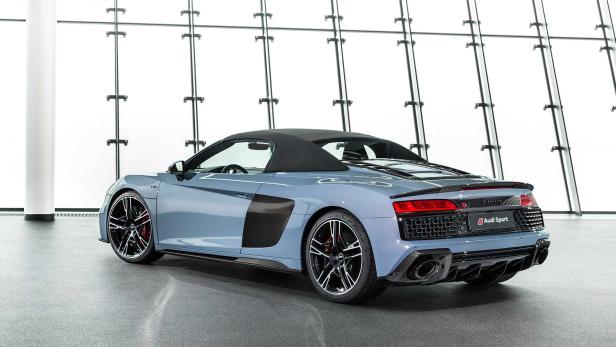 Ein blauer Audi R8 Spyder steht vor einer Glaswand.