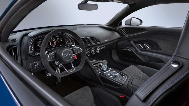Innenraum eines Audi R8 mit schwarzem Leder und digitalen Anzeigen.