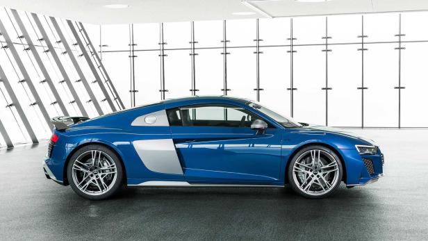 Ein blauer Audi R8 steht in einem modernen Ausstellungsraum.