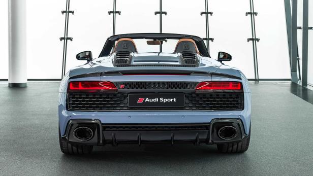 Die Rückansicht eines blauen Audi R8 Spyder mit geöffnetem Verdeck.