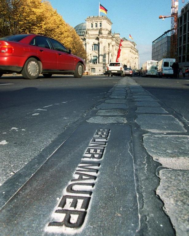 Die Pflastersteine markieren den Verlauf der Berliner Mauer vor dem Reichstagsgebäude.