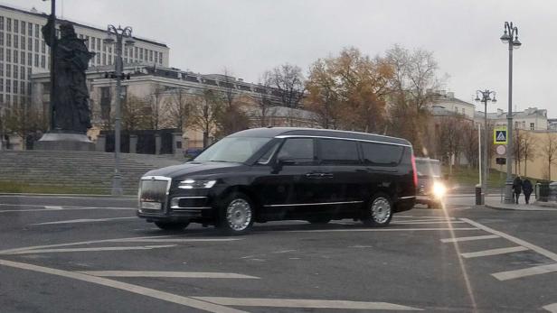 Ein schwarzer Aurus-Kleinbus fährt durch eine städtische Umgebung in Moskau.