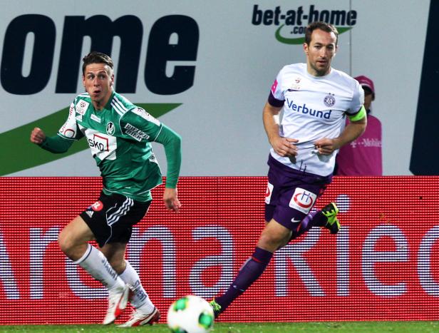 Zwei Fußballspieler kämpfen um den Ball während eines Spiels.