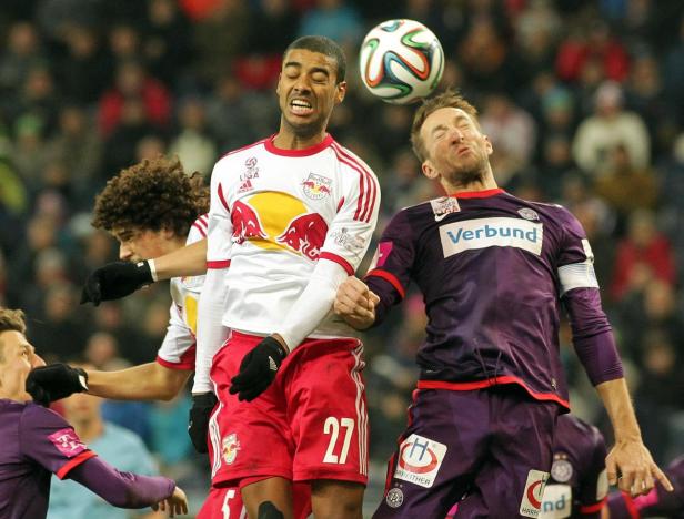 Zwei Fußballspieler kämpfen um den Ball während eines Spiels.