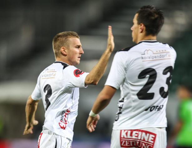 Zwei Fußballspieler geben sich ein High-Five auf dem Spielfeld.