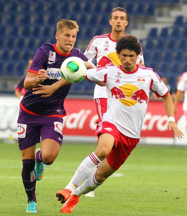 Zwei Fußballspieler kämpfen um den Ball während eines Spiels.