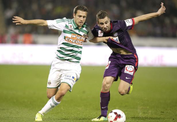 Zwei Fußballspieler kämpfen um den Ball während eines Spiels.