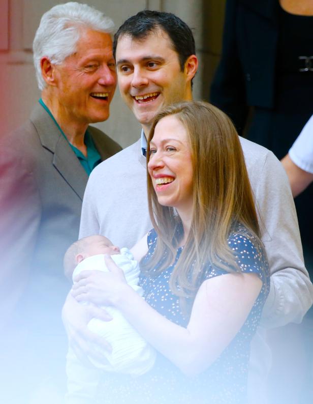 Chelsea Clinton hält ihr neugeborenes Baby im Arm, während Bill Clinton und ihr Ehemann Marc Mezvinsky lächeln.
