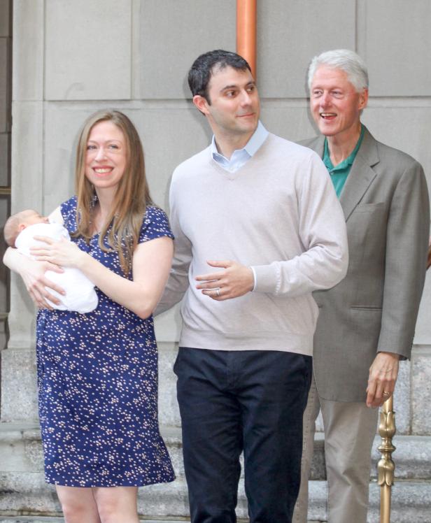 Chelsea Clinton mit ihrem Ehemann und Vater Bill Clinton, ein Baby haltend.
