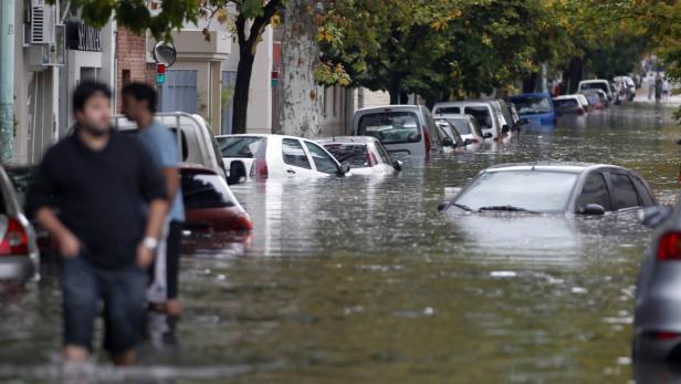Eine überflutete Straße mit Autos, die im Wasser stehen.