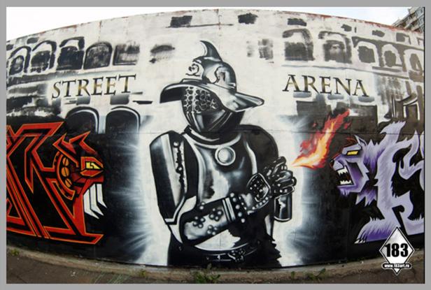 Ein Graffiti zeigt einen Gladiator zwischen einem roten Drachen und einem lila Monster vor einer Arena.
