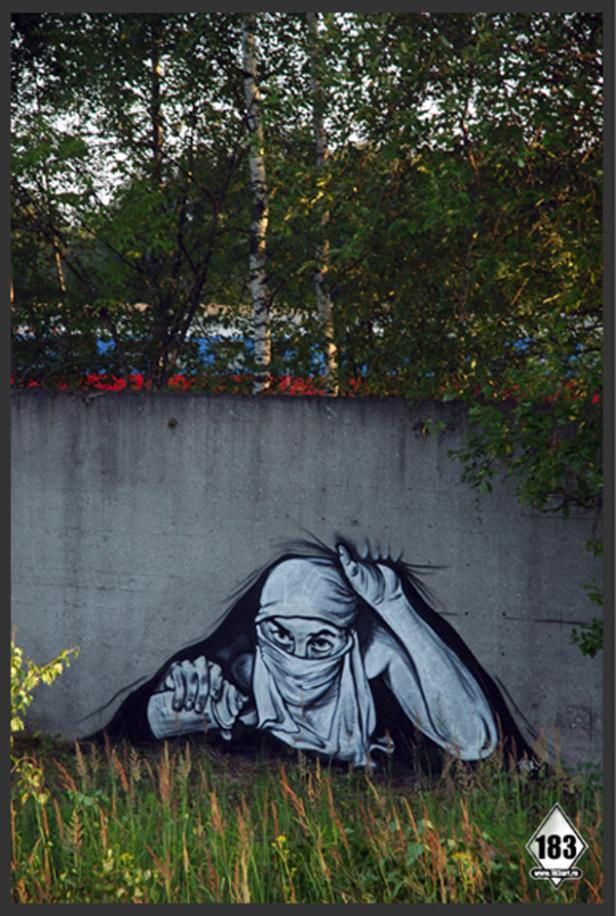 Graffiti auf einer Betonmauer zeigt eine Person mit einem Tuch vor dem Gesicht.