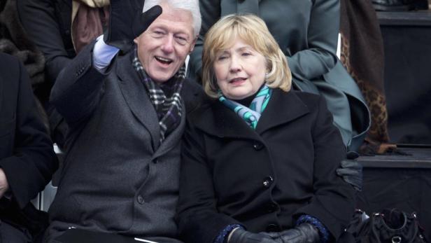 Bill und Hillary Clinton sitzen zusammen und winken.