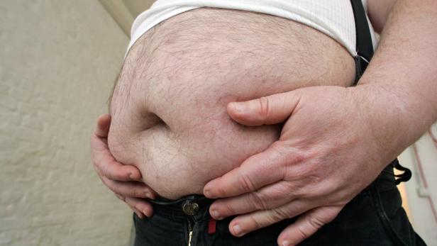 Ein Mann hält seinen Bauch in den Händen.