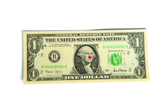 Ein US-Dollar-Schein mit einer roten Clownsnase auf dem Porträt von George Washington.