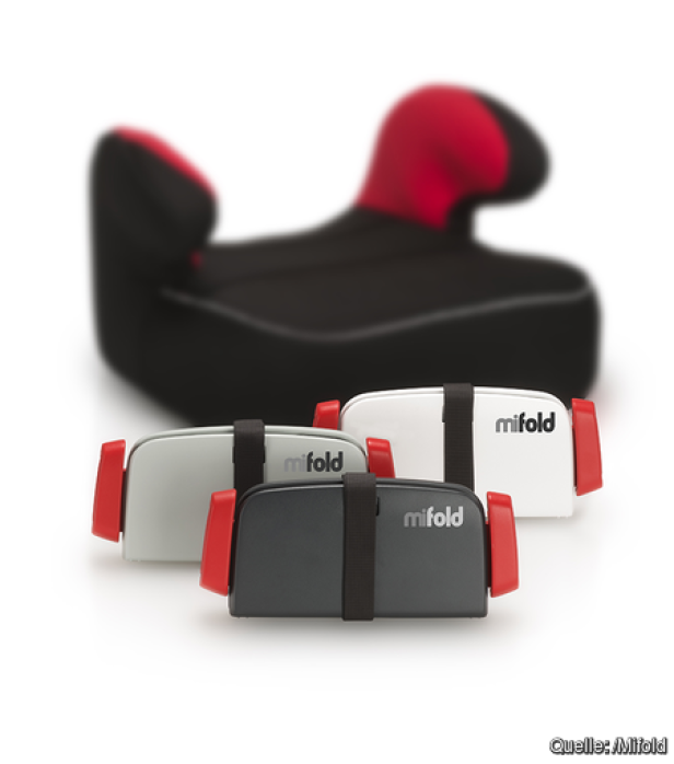 Drei zusammengeklappte Mifold-Kindersitze in Grau, Schwarz und Weiß vor einem schwarzen Kindersitz mit roter Kopfstütze.