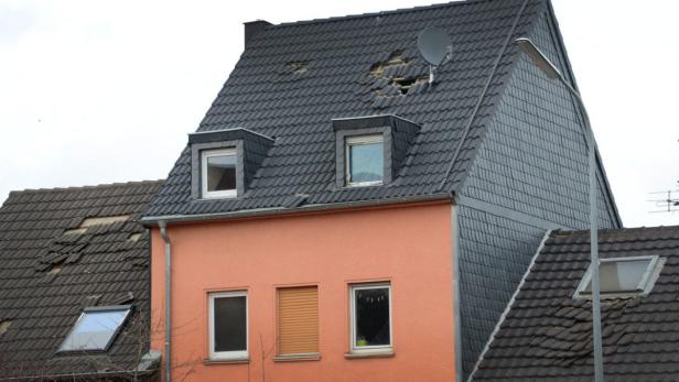 Ein Haus mit einem beschädigten Dach und einer Satellitenschüssel.