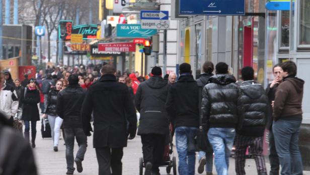 Eine belebte Einkaufsstraße mit vielen Menschen und Geschäften in der Stadt.