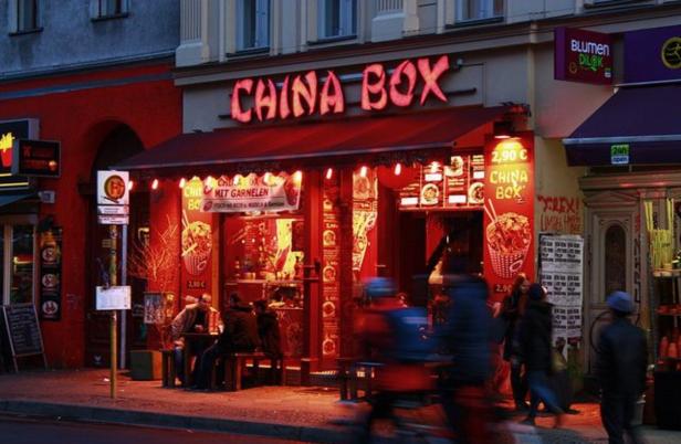 Das rot beleuchtete Restaurant „China Box“ in einer Stadt.