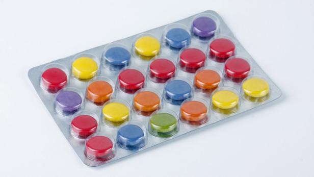Eine Blisterpackung mit bunten, runden Bonbons oder Tabletten.