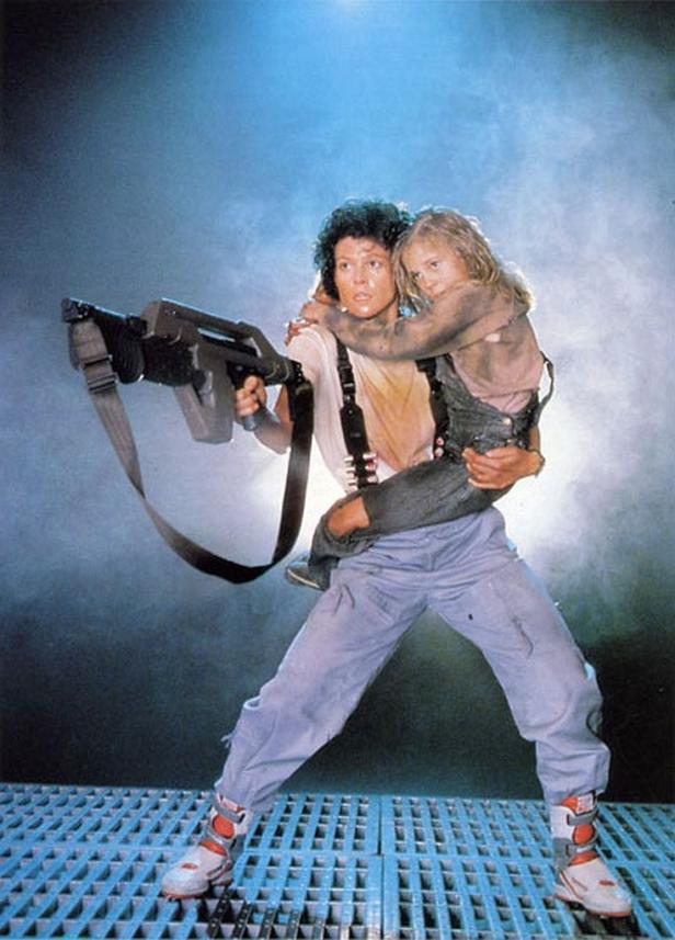 Ripley bewaffnet und mit Newt im Arm in einer Szene aus „Aliens – Die Rückkehr“.