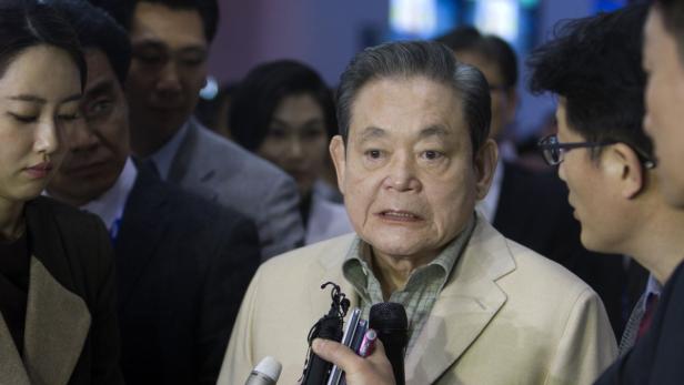 Ein Mann wird von Reportern mit Mikrofonen umringt.