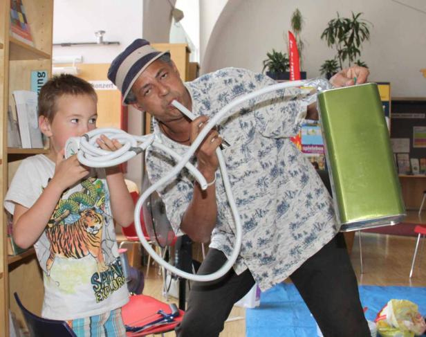 Ein Mann und ein Junge spielen mit einem Schlauch und einer Dose, um Musik zu machen.