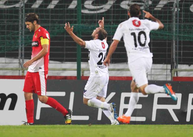 Fußballspieler jubeln auf dem Spielfeld.