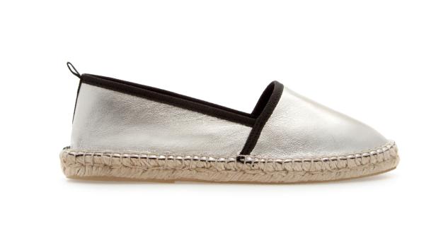 Ein silberner Espadrille-Slipper mit schwarzer Einfassung.