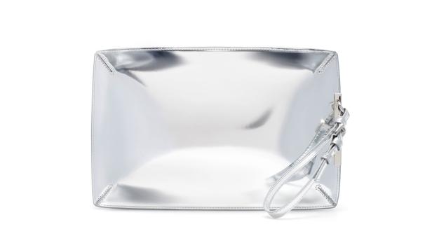 Eine silberne Handtasche mit einem Handgelenkriemen auf einem weißen Hintergrund.