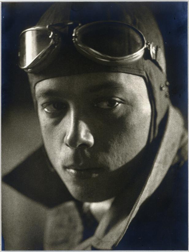 Ein Porträt eines jungen Mannes mit Fliegerhaube und Schutzbrille.