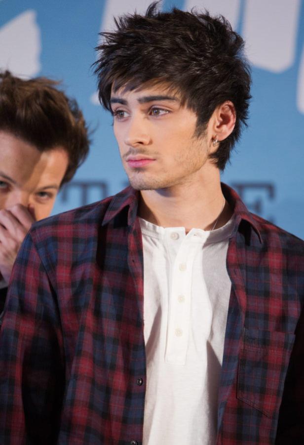 Zayn Malik trägt ein rot-blaues Flanellhemd und einen Ohrring.