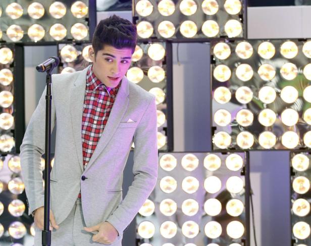 Zayn Malik singt vor einer Wand aus Scheinwerfern.