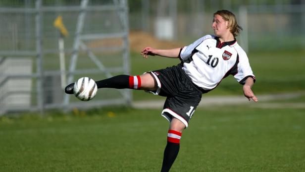 Ein Fußballspieler im österreichischen Nationaltrikot schießt einen Ball.
