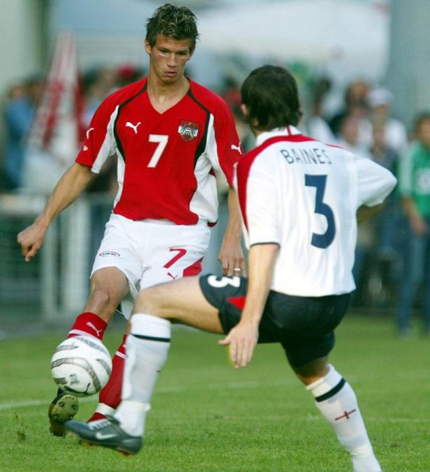 Ein österreichischer Fußballspieler mit der Nummer 7 am Ball, im Zweikampf mit einem Gegenspieler.