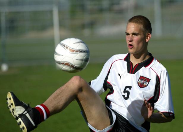 Ein junger Fußballspieler im österreichischen Nationaltrikot jongliert einen Ball mit dem Knie.