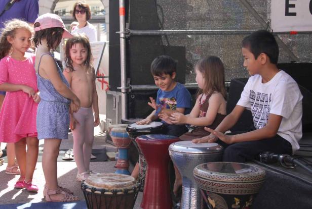 Eine Gruppe Kinder spielt gemeinsam auf verschiedenen Trommeln.