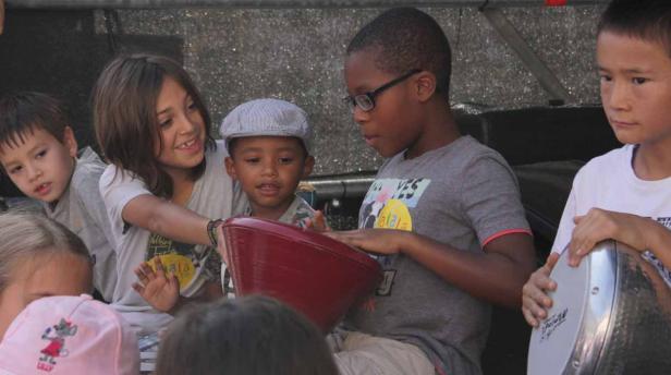 Eine Gruppe von Kindern spielt gemeinsam auf Trommeln.