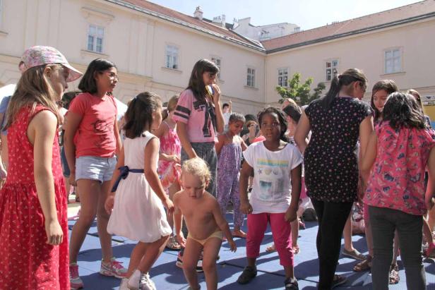 Eine Gruppe von Kindern steht im Freien auf einem Platz.