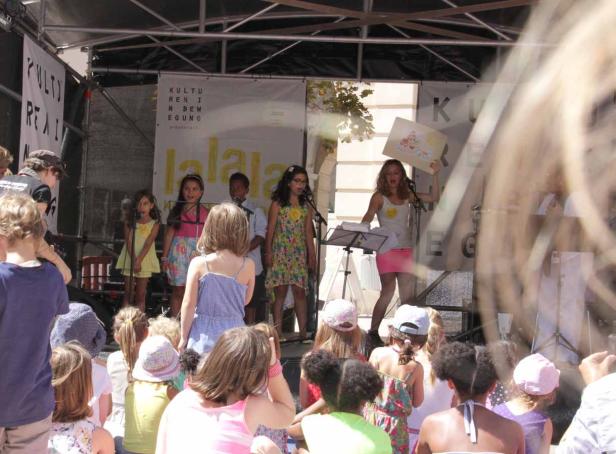 Eine Gruppe Kinder tritt auf einer Bühne vor einem Publikum auf.