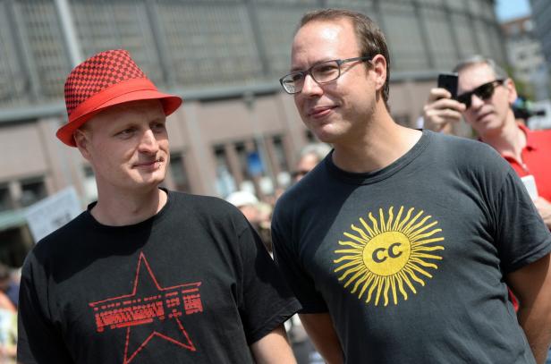 Markus Beckedahl (re.), Gründer und Chefredakteur von Netzpolitik.org und Blogger André Meister Zwei Männer stehen zusammen, einer mit einem roten Hut und einem T-Shirt mit Stern, der andere mit Brille und CC-T-Shirt.