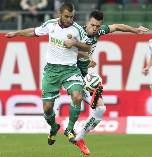 Zwei Fußballspieler kämpfen um den Ball während eines Spiels.