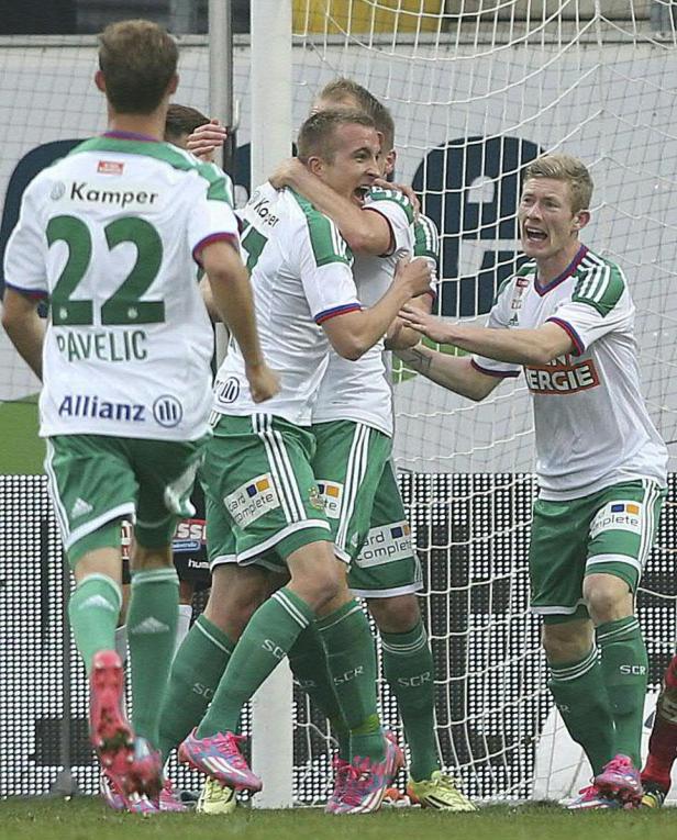 Fußballspieler in weißen und grünen Trikots feiern ein Tor.