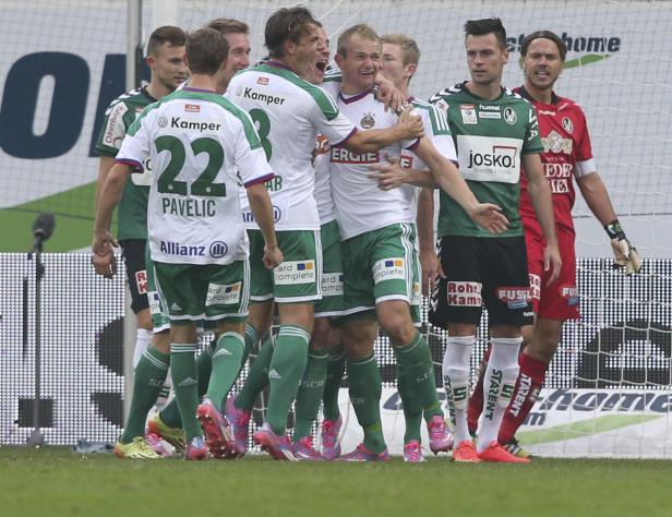Fußballspieler in Grün und Weiß feiern ein Tor.